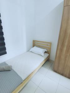 un piccolo letto in una camera con struttura in legno di The Ken & Hiro Stay a Sepang
