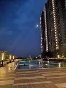 una piscina di fronte a un edificio di notte di The Ken & Hiro Stay a Sepang