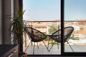 Duas cadeiras numa varanda com vista para a cidade em Urban Sabadell Apartamentos em Sabadell