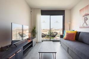 uma sala de estar com um sofá e uma televisão em Urban Sabadell Apartamentos em Sabadell