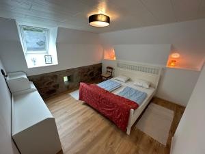 een kleine slaapkamer met een bed en een koelkast bij Moderne Wohnung :: traumhafte Natur in Moholm