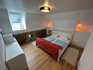a small bedroom with a bed and a refrigerator at Moderne Wohnung :: traumhafte Natur in Moholm