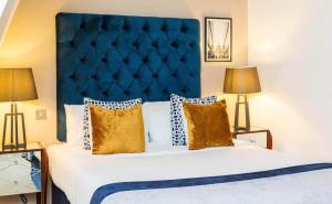 Monument Serviced Apartments في لندن: غرفة نوم مع سرير كبير مع اللوح الأمامي الأزرق