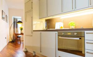 a kitchen with white cabinets and a stainless steel oven at Monument Serviced Apartments in London