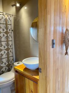 a bathroom with a toilet and a bowl on a wooden counter at Tinyhouse Pichi I - vida lenta en Patagonia Costa in Calbuco