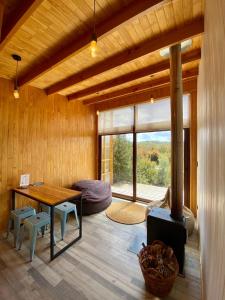 a living room with a table and a fireplace at Tinyhouse Pichi I - vida lenta en Patagonia Costa in Calbuco