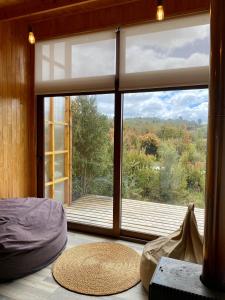 a room with a large window with a view at Tinyhouse Pichi I - vida lenta en Patagonia Costa in Calbuco