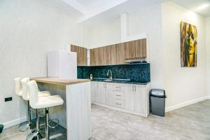 a kitchen with a sink and a counter with white cabinets at Two-Bedroom Apartment City Center in Baku