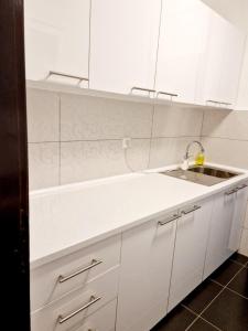 a kitchen with white cabinets and a sink at Esperanto in Vranje