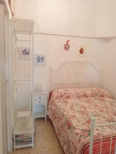een witte slaapkamer met een bed en een witte plank bij La Casetta in Ostuni