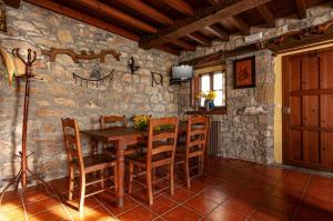 comedor con mesa de madera y sillas en Casa BegoñaSituada en Sardedo Ribadesella en Linares
