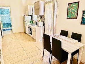 a kitchen with a table and chairs and a kitchen with a refrigerator at Glenda’s House in Siracusa