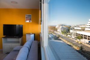 a living room with a couch and a large window at 3C’s Athens South @Delta: SNFCC / Faliro Seaview Penthouse in Athens