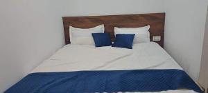 a large bed with blue and white sheets and pillows at Griham Inn in Guwahati