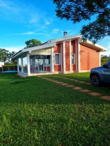 una casa con un coche aparcado delante de ella en Riviera de Santa Cristina III, piscina e represa, tijolinho vermelho, en Itaí