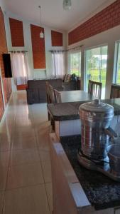 eine Küche mit einem Tisch und ein Wohnzimmer in der Unterkunft Riviera de Santa Cristina III, piscina e represa, tijolinho vermelho in Itaí