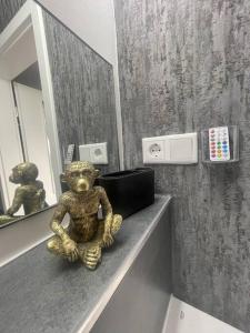una estatua de un oso de peluche sentado en un mostrador en un baño en GRYT Home - Appartment L - Nähe Nordsee, en Ramhusen