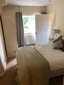 a bedroom with a large bed and a window at The Grooms Den in Fenny Compton