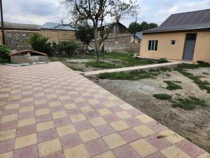 a yard with a brick building and a sidewalk at Michael House in Ganja