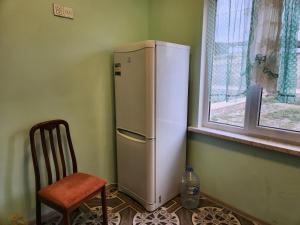 a refrigerator in a room with a chair and a window at Michael House in Ganja