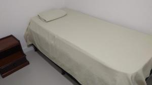 um quarto com uma cama e uma mesa de cabeceira em Apartamento frente para a piscina a uma quadra da praia em Florianópolis mais 37 fotografias