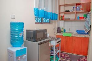 a kitchen with a microwave and a television on a refrigerator at Unique Homes One- Bedroom Apartment in Kilifi