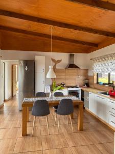 a kitchen with a wooden table and chairs at Oasis Rapanui Bungalow frente al Mar in Hanga Roa