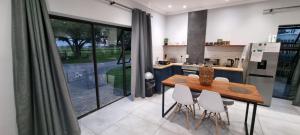 a kitchen with a wooden table and white chairs at bird haven self catering in Donny-brook