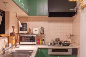 a small kitchen with green cabinets and a sink at Cachtte Nagisa - Vacation STAY 95387v in Zushi