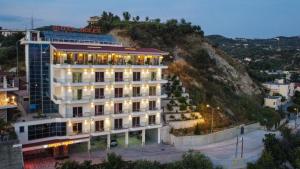 a building with lights on top of a mountain at Hotel VD Roleks in Vlorë