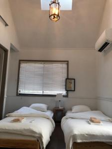 逗子市にあるCachtte Nagisa - Vacation STAY 95387vの窓とシャンデリアが備わる客室で、ベッド2台が備わります。