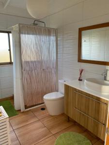 y baño con bañera, lavabo y aseo. en Oasis Rapanui Bungalow frente al Mar, en Hanga Roa