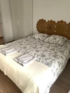 a bed with a black and white comforter and pillows at Casa de los Abuelos Albino in Pinilla del Valle