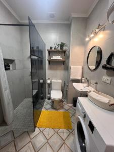 uma casa de banho com um chuveiro, um WC e um lavatório. em Fiesta Apartment on Franka 2BR-6P em Lviv