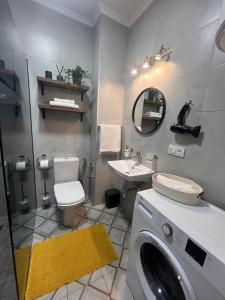 uma casa de banho com uma máquina de lavar roupa e um lavatório em Fiesta Apartment on Franka 2BR-6P em Lviv