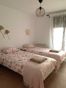 a bedroom with two beds and a window at Casa de los Abuelos Albino in Pinilla del Valle