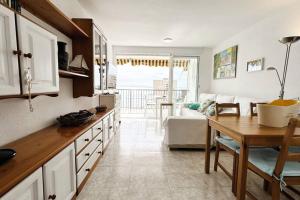 a kitchen with a table and a living room at The Beach Apartment in El Puig