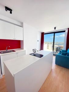 uma cozinha branca com um lavatório e uma bancada em Citizen Suites em Sliema