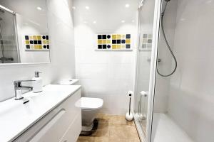 a white bathroom with a shower and a toilet at The Beach Apartment in El Puig +21 photos