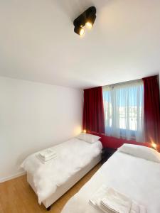 um quarto com duas camas e uma janela em Citizen Suites em Sliema
