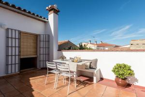 un patio con mesa y sillas en una pared blanca en Casa del Aire, en Aldea de Trujillo