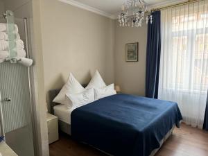 a bedroom with a blue bed with white pillows at Apartment Baden-Baden Altstadt Zentrum in Baden-Baden