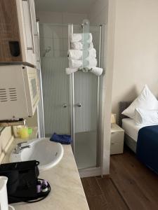 a bathroom with a sink and a shower with towels at Apartment Baden-Baden Altstadt Zentrum in Baden-Baden +12 photos