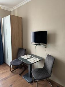 a desk with two chairs and a computer monitor on a wall at Apartment Baden-Baden Altstadt Zentrum in Baden-Baden