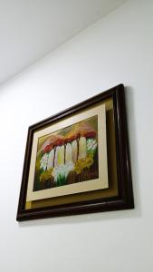 a framed painting of flowers on a wall at Di Costa Hotel in Piura