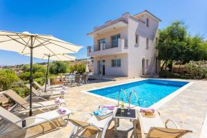 a villa with a swimming pool and a house at Villa Panorama Tessera in Droushia