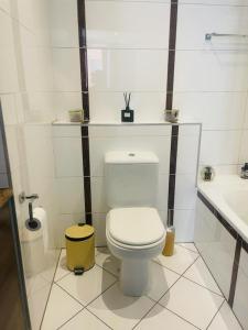 a white bathroom with a toilet and a sink at MarbleNights Bedford in Johannesburg +20 photos