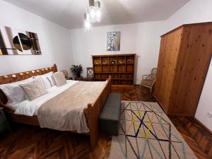 a bedroom with a large bed and wooden floors at Eden Garden in Braşov
