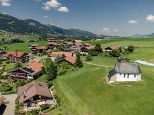 une vue aérienne sur un village dans un champ verdoyant dans l'établissement Ferienwohnung Alpenherz, à Obermaiselstein