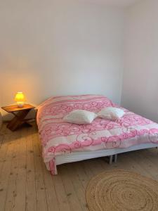 een slaapkamer met een roze bed met kussens en een tafel bij Captivating 3-Bed House in Ognen in Ognen